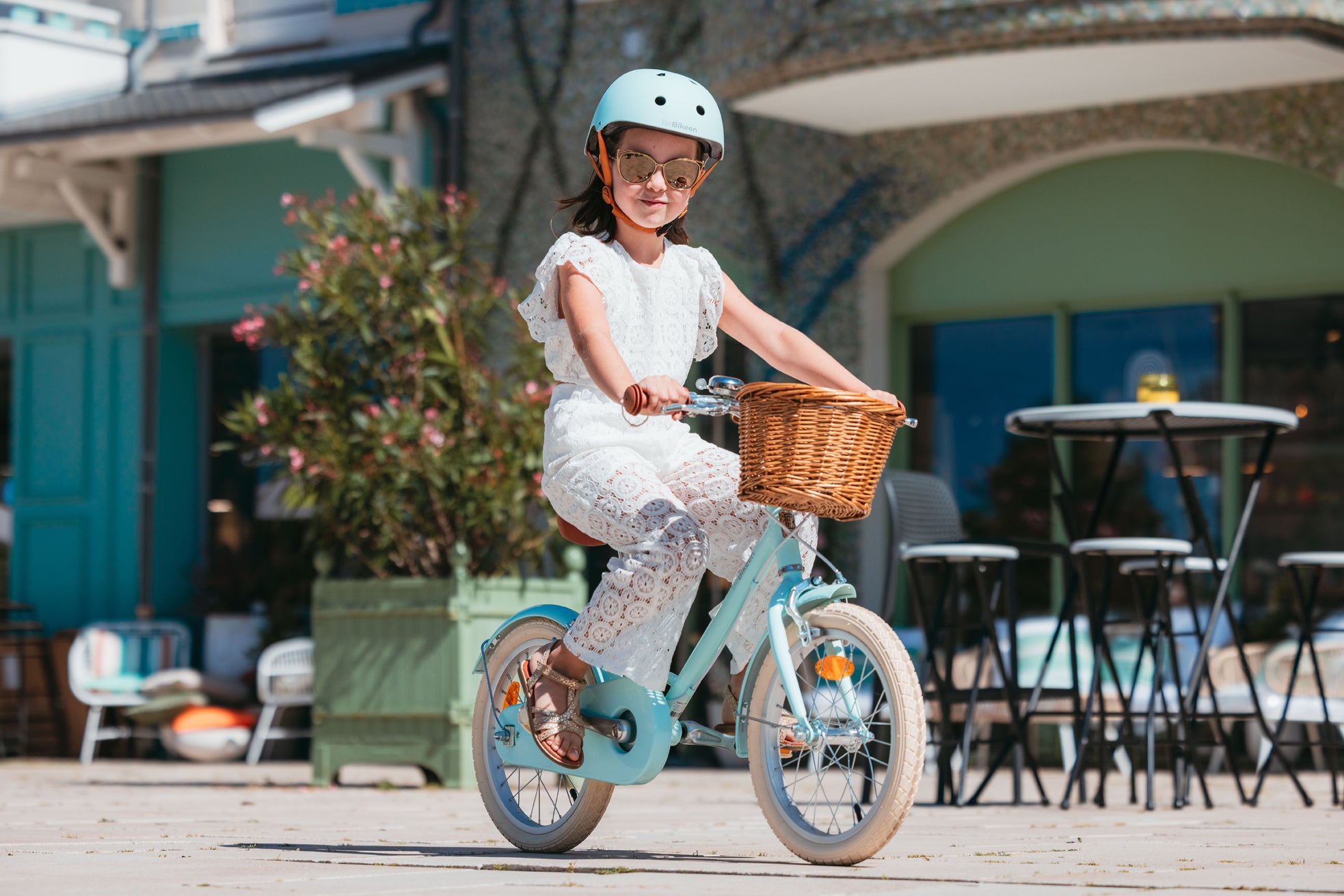 Fille de 6 ans roule avec élégance sur vélo enfant Bebikeen 16 pouces. Elle porte un casque XS bleu turquoise assorti.