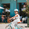 Fille de 6 ans portant le casque vélo BeBikeen XS bleu turquoise, assorti à son vélo Bebikeen.