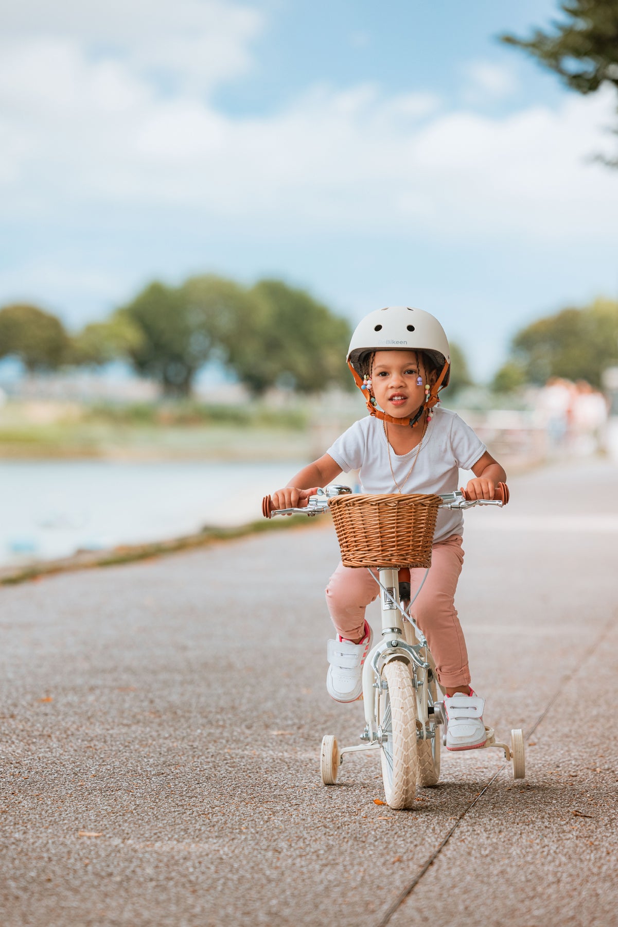 Fille portant le casque vélo enfant BeBikeen XS crème, 2 à 6 ans, sur vélo 12 pouces crème Bebikeen, vue de face.