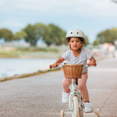 Fille portant le casque vélo enfant BeBikeen XS crème, 2 à 6 ans, sur vélo 12 pouces crème Bebikeen, vue de face.
