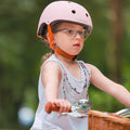 Fille portant le casque vélo enfant BeBikeen XS rose, 2 à 6 ans, pédalant sur vélo Bebikeen, vue de 3/4.