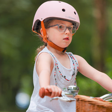 Fille portant le casque vélo enfant BeBikeen XS rose, 2 à 6 ans, pédalant sur vélo Bebikeen, vue de 3/4.