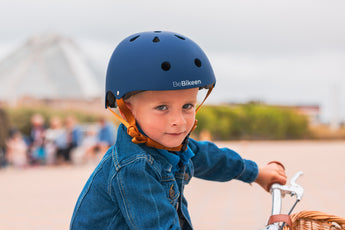 Garçon portant un casque de vélo Bebikeen XS bleu marine, conçu pour les enfants de 2 à 6 ans.