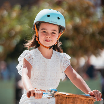 Fillette souriante portant le casque vélo enfant Bebikeen XS bleu turquoise, conçu pour les enfants de 2 à 6 ans.