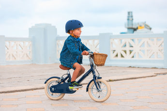 Garçon de 3 ans roule facilement sur le vélo léger Bebikeen 12 pouces bleu marine au Touquet. Vélo profil droit sans roues stabilisatrices.