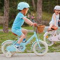 Garçon de 3 ans sur le vélo enfant Bebikeen 12 pouces bleu turquoise, 2 à 4 ans, profil droit avec roues stabilisatrices.