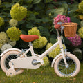 Vélo enfant Bebikeen 12 pouces crème léger, 2 à 4 ans, profil droit avec roues stabilisatrices, selle marron et panier en osier.
