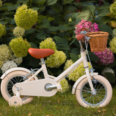 Vélo enfant Bebikeen 12 pouces crème léger, 2 à 4 ans, profil droit avec roues stabilisatrices, selle marron et panier en osier.