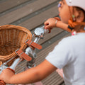 Détail du vélo enfant Bebikeen 12 pouces rose léger : panier en osier naturel avec sangles simili cuir et jolie sonnette chromée.