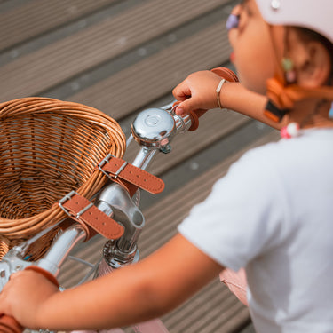 Détail du vélo enfant Bebikeen 12 pouces rose léger : panier en osier naturel avec sangles simili cuir et jolie sonnette chromée.