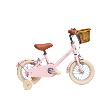 Vélo enfant Bebikeen 12 pouces rose léger, 2 à 4 ans, profil droit avec roues stabilisatrices et panier en osier naturel.