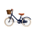 Vélo léger enfant Bebikeen 16 pouces bleu marine, 4 à 6 ans, profil gauche avec selle marron en simili cuir et panier en osier.