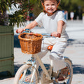 Fille de 5 ans pédale sur vélo Bebikeen 16 pouces crème léger, 4 à 6 ans, vue de face avec panier en osier naturel.