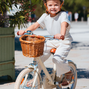 Fille de 5 ans pédale sur vélo Bebikeen 16 pouces crème léger, 4 à 6 ans, vue de face avec panier en osier naturel.