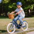 Garçon pédalant sur vélo léger enfant Bebikeen 16 pouces bleu marine, 4 à 6 ans, portant un casque assorti au vélo.